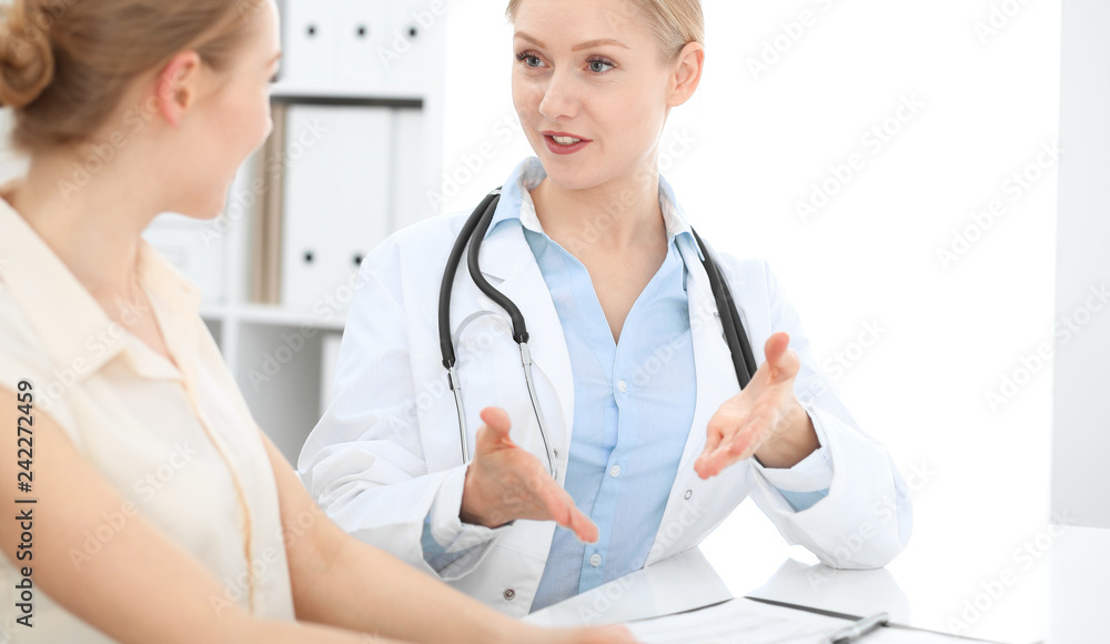 Doctor and patient talking in hospital office while sitting at the desk. Health care and client service in medicine Doctor and patient talking in hospital office while sitting at the desk. Health care and client service in medicine