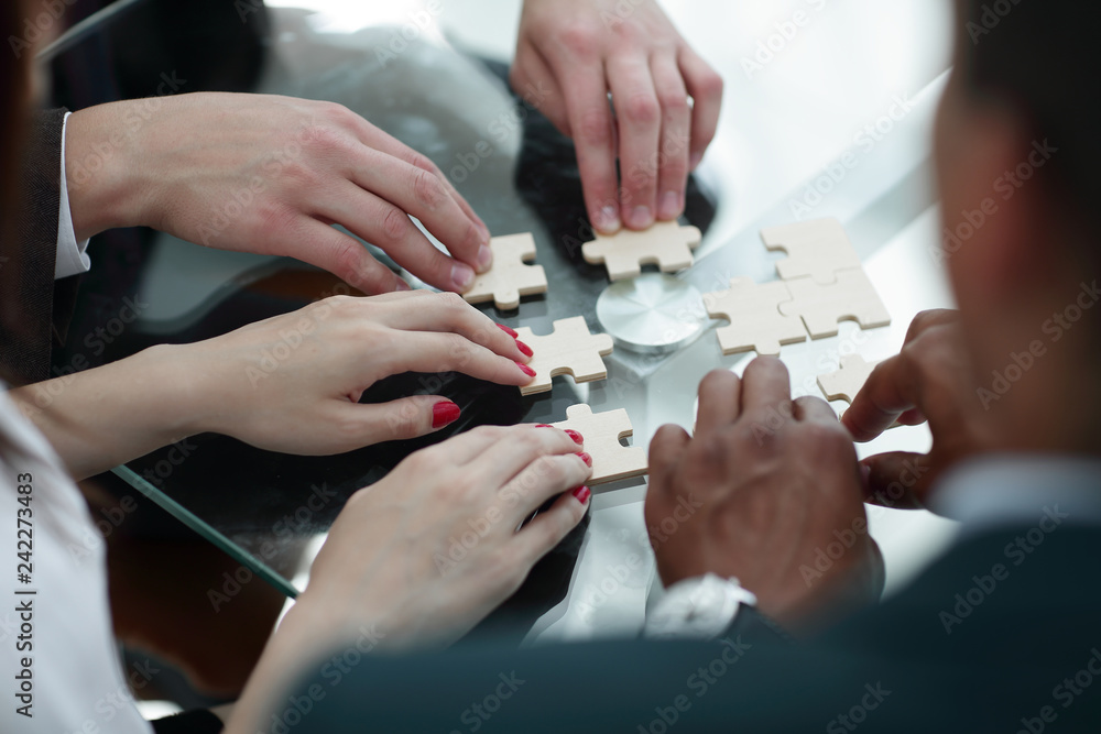 close up. business team assembling puzzle pieces. close up. business team assembling puzzle pieces.