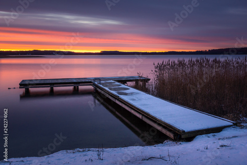Fototapeta Naklejka Na Ścianę i Meble -  Sunrise over the Swiecajty lake and wooden footbridge near Wegorzewo, Masuria, Poland