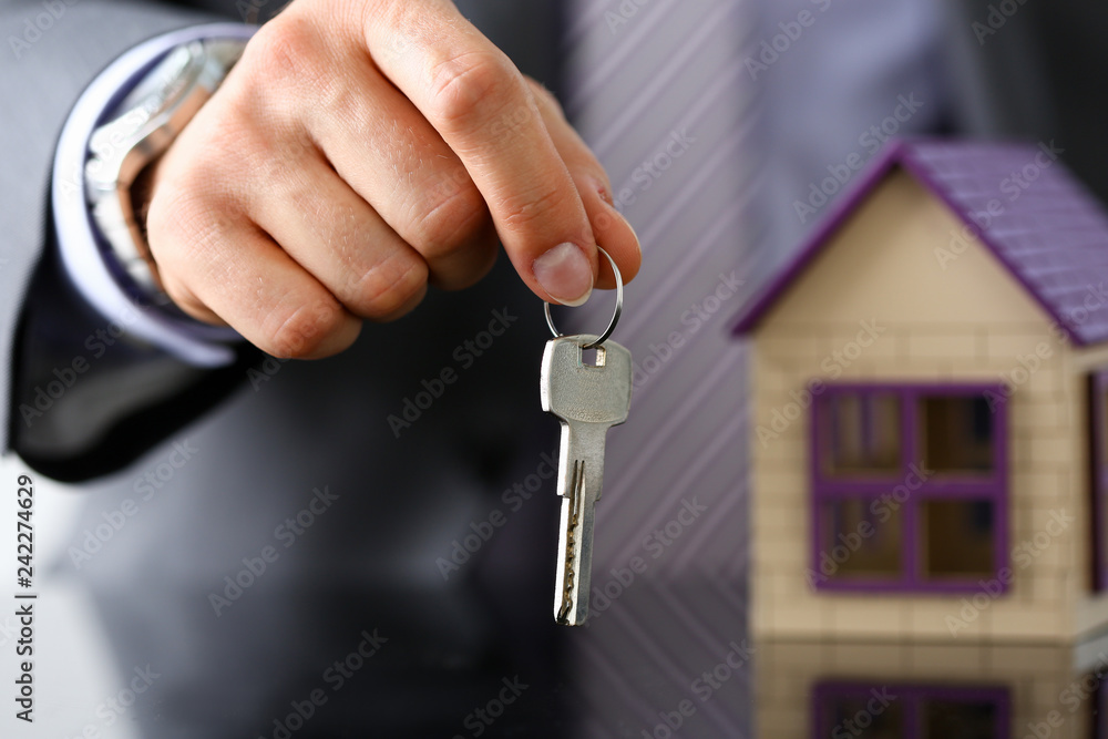 Man in suit and tie hold in hand silver key giving