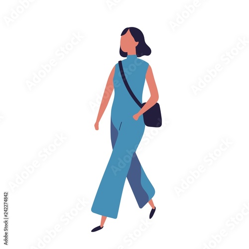 Cute funny young teenage girl dressed in stylish blue jumpsuit walking to sch...