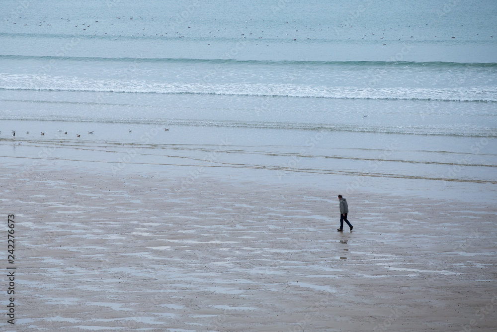 homme seul marchant sur la plage