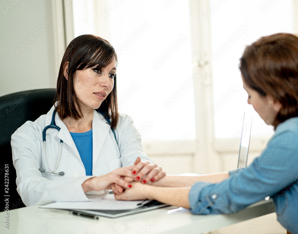Female doctor explaining bad news diagnosis to desperate sad patient comforting her with sympathy Female doctor explaining bad news diagnosis to desperate sad patient comforting her with sympathy