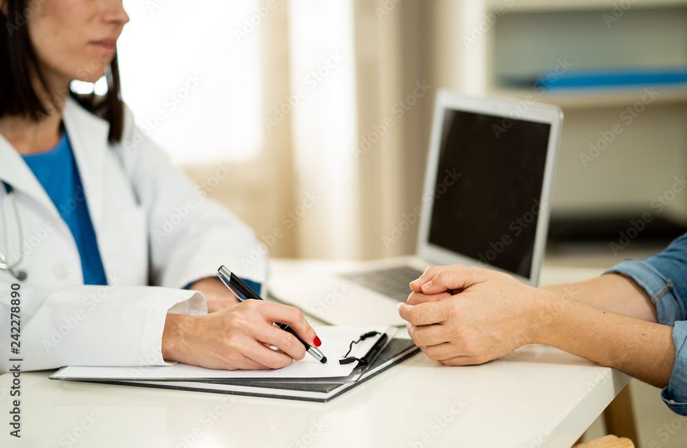 Fototapeta premium Close up of woman doctor and patient having consultation in hospital room