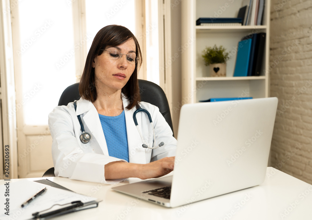Female doctor working on medical expertise and searching information on laptop at hospital office Female doctor working on medical expertise and searching information on laptop at hospital office