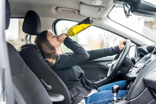 Woman drinking alcohol while driving a car