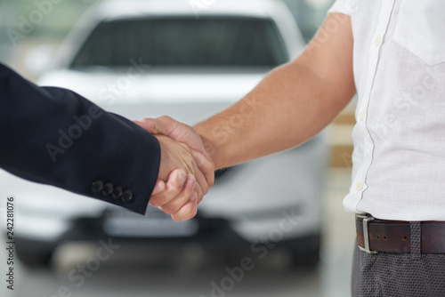 Handshake close up in car dealership.
