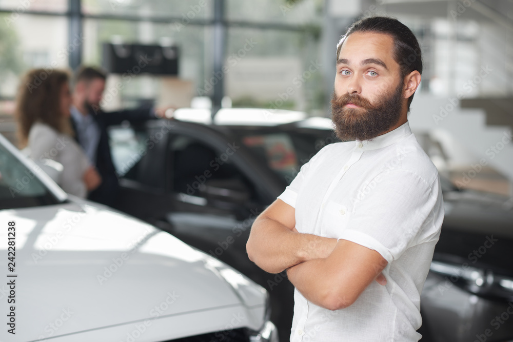 Brutal man posing in car dealership. Brutal man posing in car dealership.