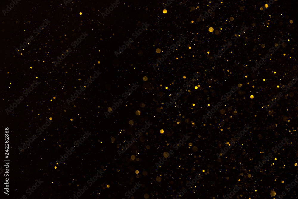 Fotografie Glitter particles shiny star dust fall on black background
