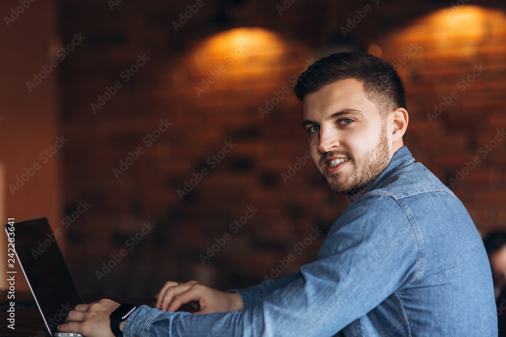 Young programmer working on a laptop in a cafe Young programmer working on a laptop in a cafe