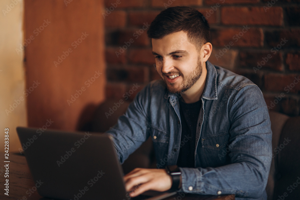 Young programmer working on a laptop in a cafe Young programmer working on a laptop in a cafe