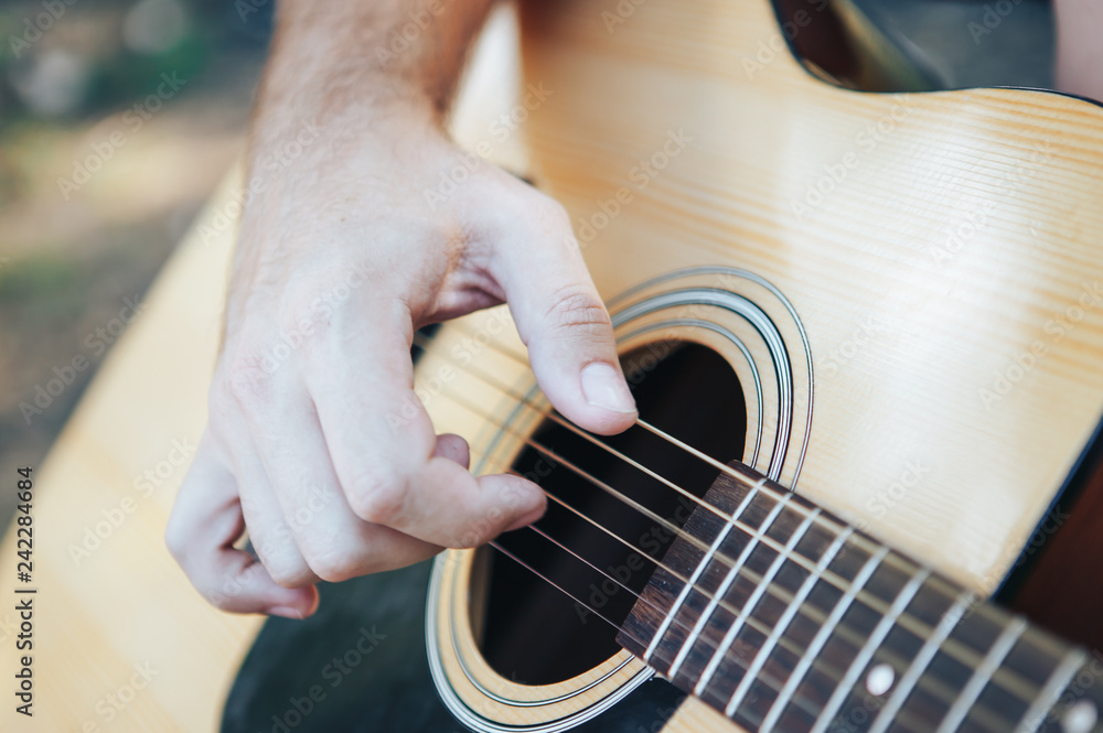 Fototapeta premium Close up of man hand playing guitar. Man playing guitar. Playing on acoustic guitar outdoor