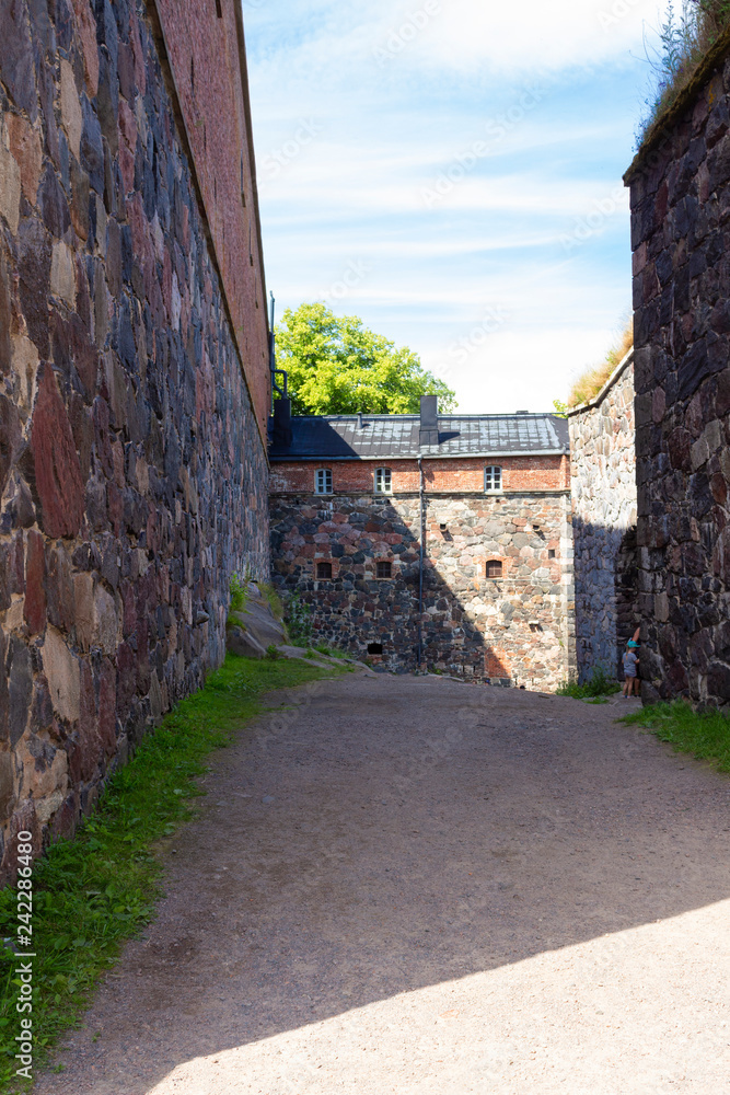 The old granite walls of the historic fortifications on Suomenlinna Forte Island are overgrown with grass in summer. Suomenlinna Island in the Gulf of Finland are tourist attractions.