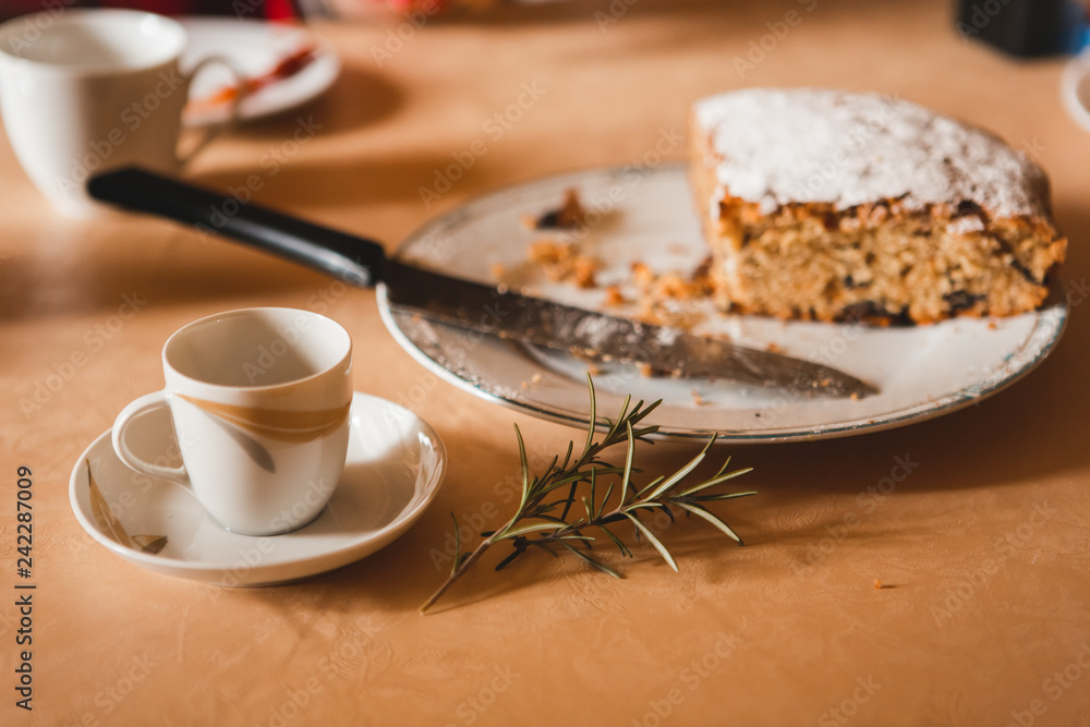 Close-up of cup of coffee and amaretto cake wit rosemary branch Close-up of cup of coffee and amaretto cake wit rosemary branch