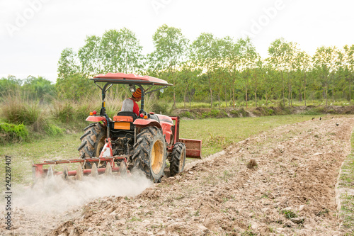 Tractor working plows a field on the farm for planting