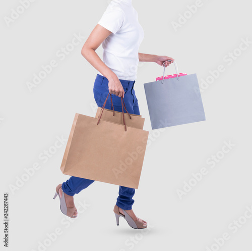 Hand holding blank brown paper shopping bag for mockup template advertising and branding isolated on white background.