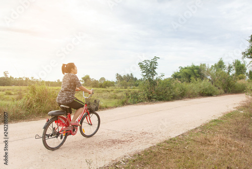 Fototapeta Naklejka Na Ścianę i Meble -  Woman riding bicycle relax in a country road.