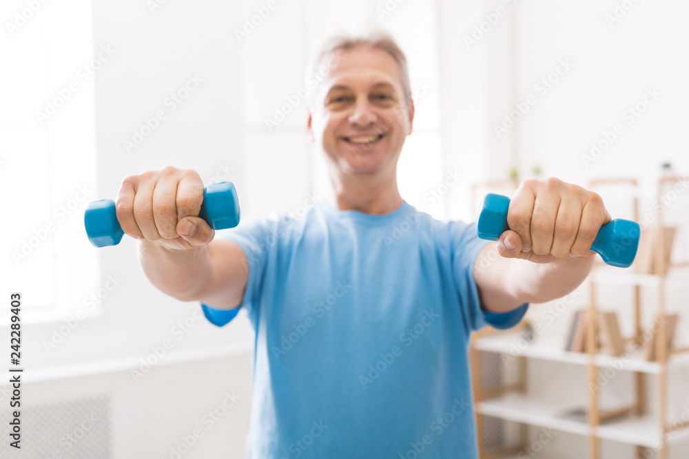 Mature man doing fitness training with dumbbells Mature man doing fitness training with dumbbells