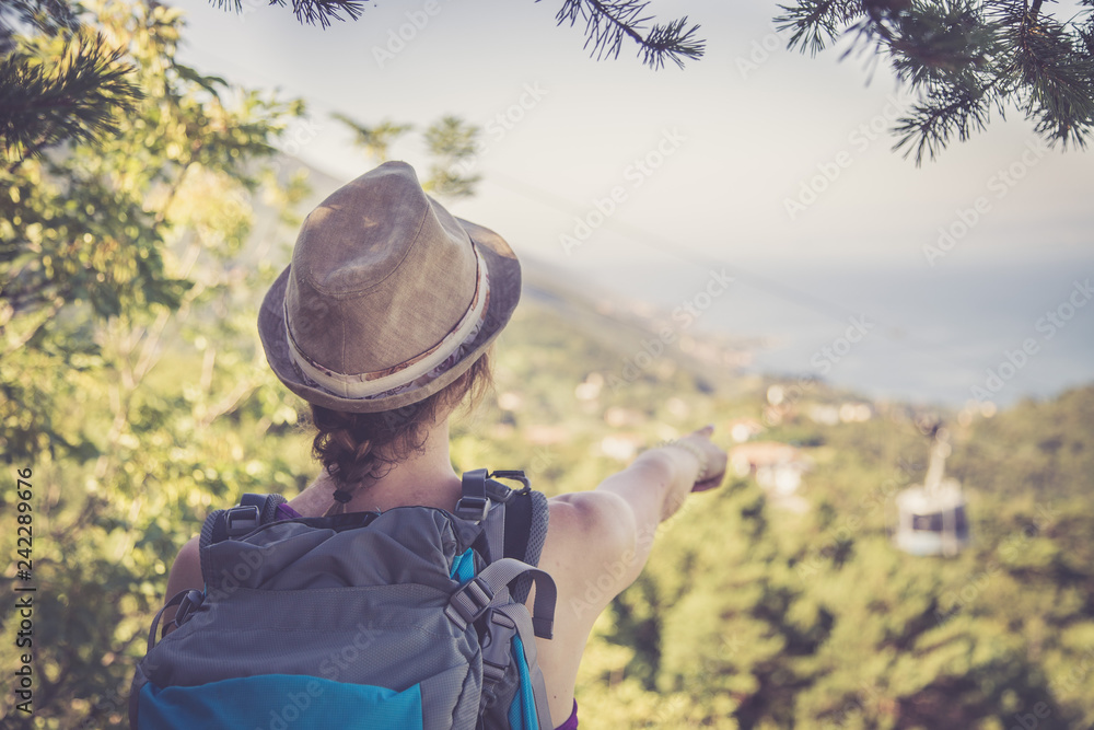 Hiking in Italy: Girl with straw hat is enjoying the view, summertime and beautiful landscape