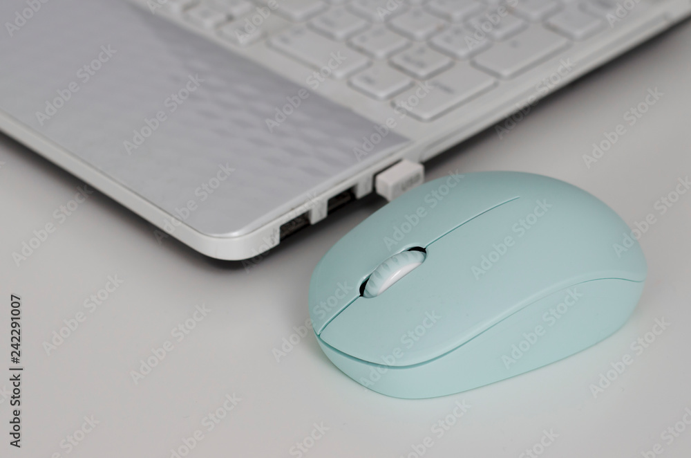 laptop keyboard and mint color mouse on the white desktop background