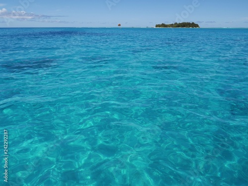 Wide shot of sparkling blue waters of Saipan lagoon, with Managaha Island in the background. Managaha is a favorite day trip destination for tourists from all parts of the world. 