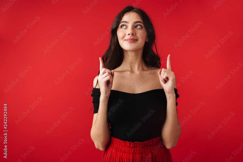 Beautiful cute young woman standing isolated over red wall background pointing. Beautiful cute young woman standing isolated over red wall background pointing.