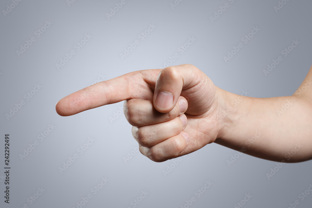 A hand pointing, touching or pushing on grey background A hand pointing, touching or pushing on grey background