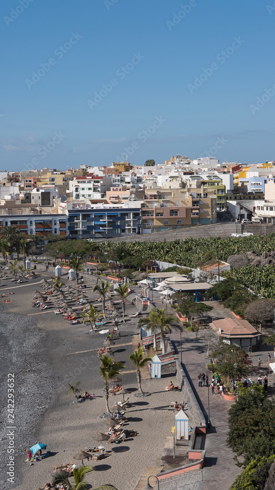 Vertical shot of the town and the small beach of black sand, lapilli and pebbles, populated all year round, Playa de San Juan, Tenerife, Canary Islands, Spain