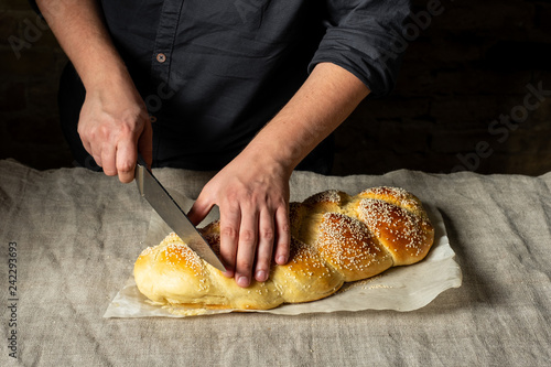Fresh baked challah jewish bread sprinkled with sesame seeds on linen cloth