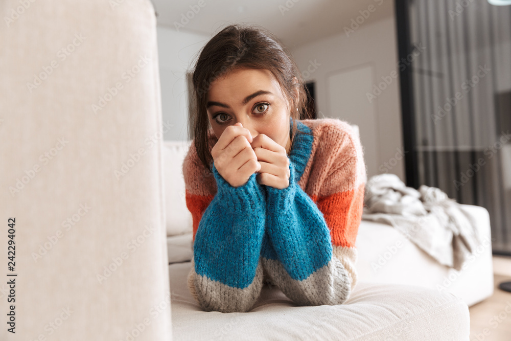 Attractive young woman wearing sweater laying on a couch Attractive young woman wearing sweater laying on a couch