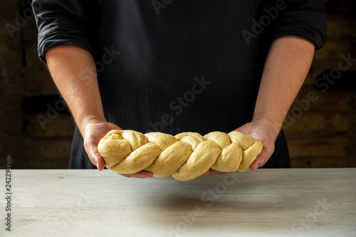 Male baker making traditional challah jewish bread. Cooking steps process food concept.