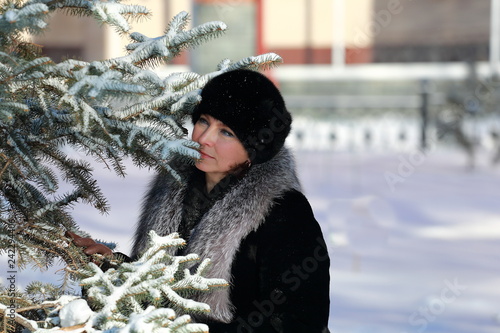 young woman in winter near spruce