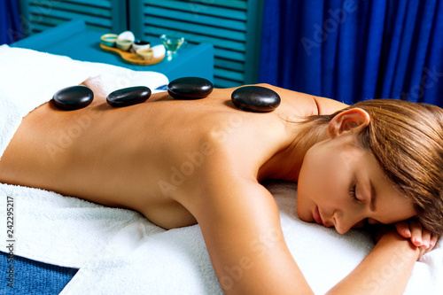 Thai therapist doing massage with hot stones.
