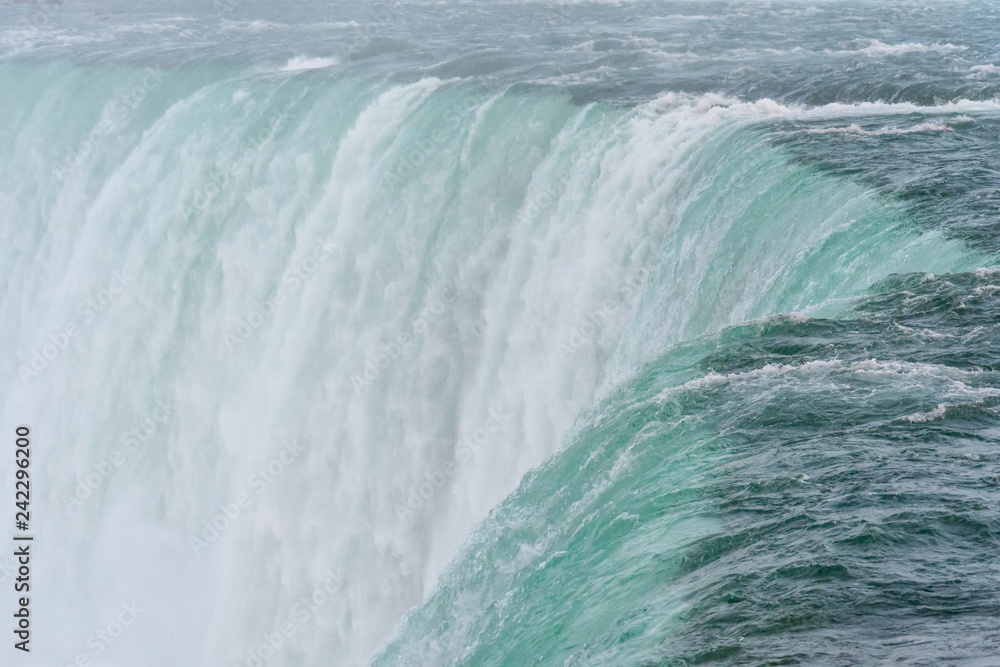 An incredible close up view of the top of the famous Niagara waterfall with its clean and cold water falling rapidly and strongly into the precipice An incredible close up view of the top of the famous Niagara waterfall with its clean and cold water falling rapidly and strongly into the precipice