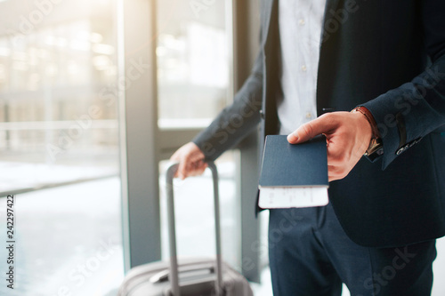 фотографія Cut view of man in suit stand at window in airport