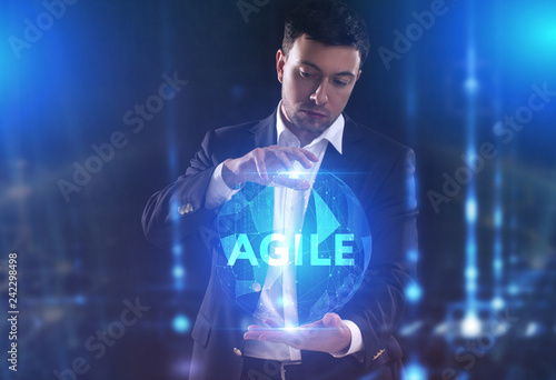 The concept of business, technology, the Internet and the network. A young entrepreneur working on a virtual screen of the future and sees the inscription: Agile