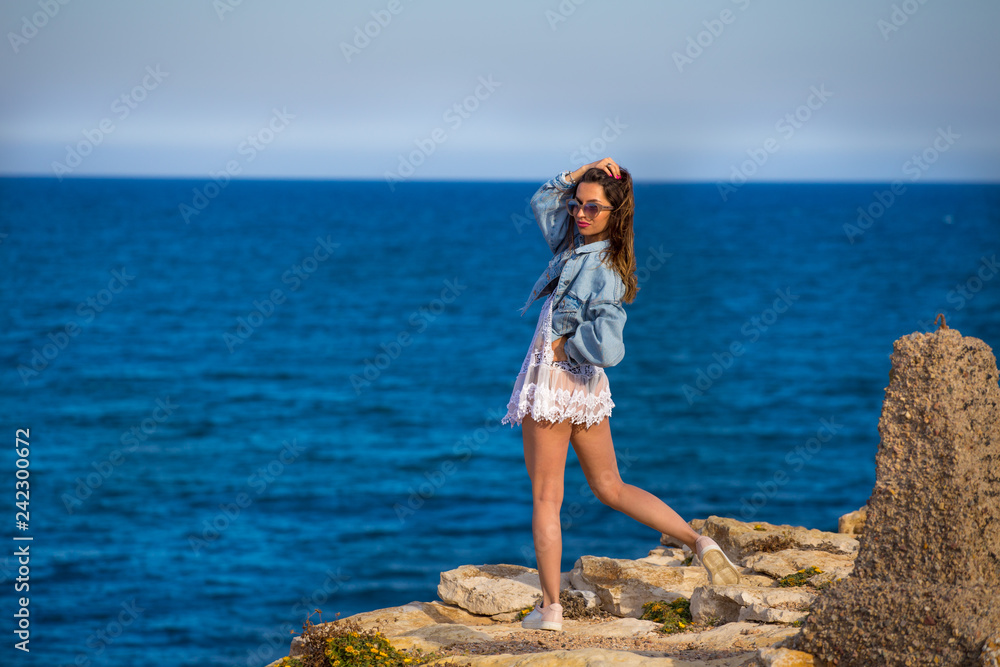 Full рушпре  portrait of young girl stand on rocks close to sea 