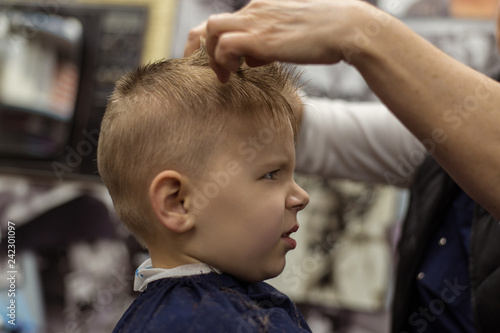 Little boy at the hairdresser. Child is scared of haircuts.