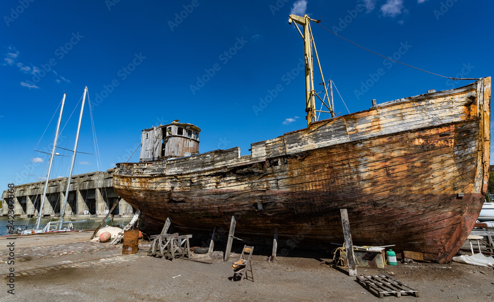 Old wooden fishing boat in a repair yard beside the World War 2 BETASOM submarine base in Bordeaux, France