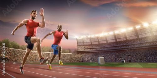 Male athletes sprinting. Two men in sport clothes run at the running track in professional stadium