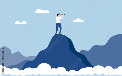 Business man standing on top of mountain above clouds cliff using binoculars looking for success