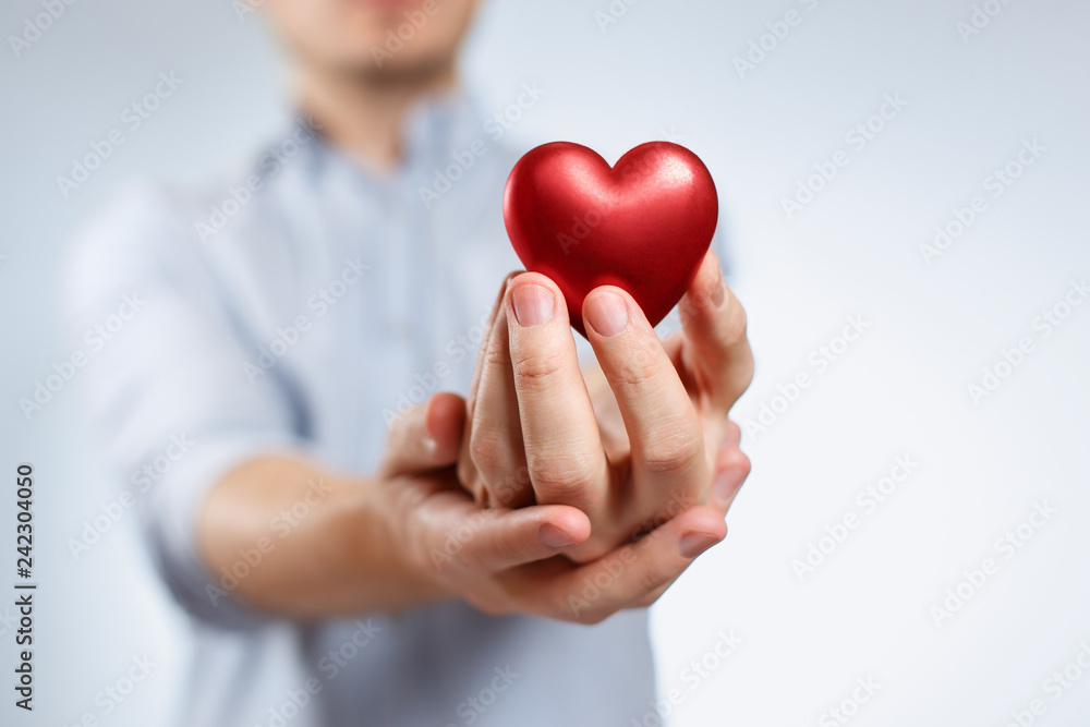Man holding a red love heart on neutral background Man holding a red love heart on neutral background