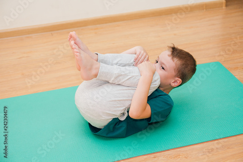 Cute little boy is learning to do yoga in the gym © irina_timokhina