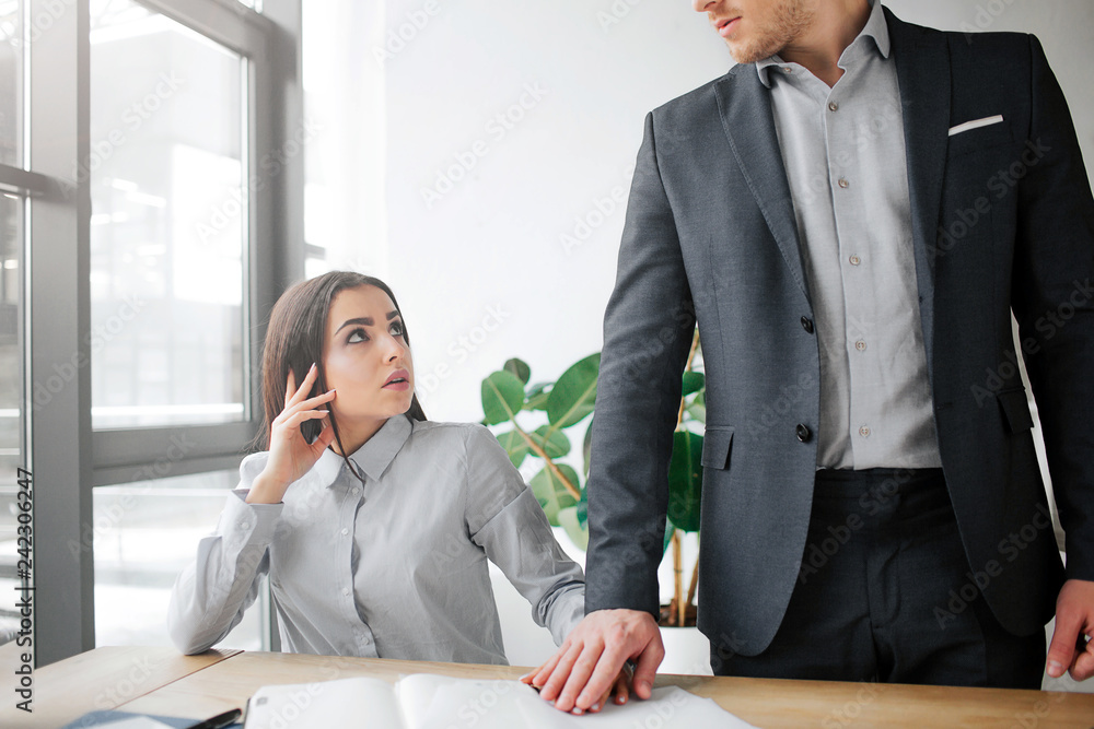 Concept harassment. Scared young woman sit at table and look at her boss. She is scared. Guy hold his hand on top of her. He wants sex with her. Concept harassment. Scared young woman sit at table and look at her boss. She is scared. Guy hold his hand on top of her. He wants sex with her.