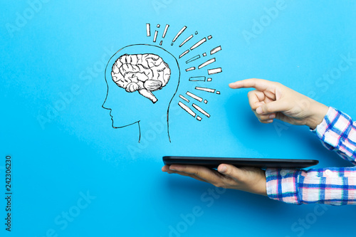 Brain illustration with a tablet computer on a blue background photo