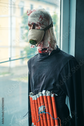 A serious crime. Terrorist wear fake suicide bombers belt. Suicide attacker. War soldier or victim. Terrorist bomber in gas mask dummy casualty in head. War or terrorism attack. Countering terrorism photo