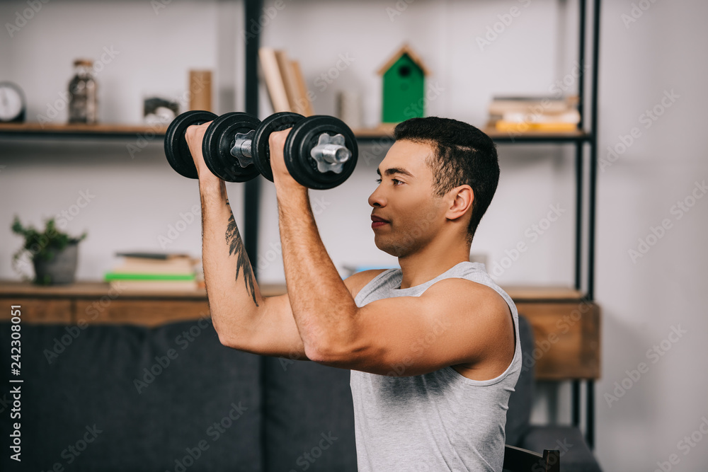 strong mixed race sportsman workout with heavy dumbbells strong mixed race sportsman workout with heavy dumbbells