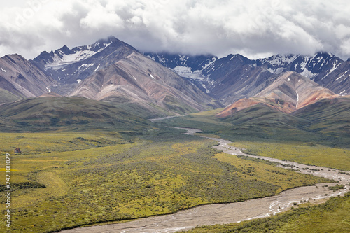 Dry River Bed Running Through Valley Between Mountains In Alaska