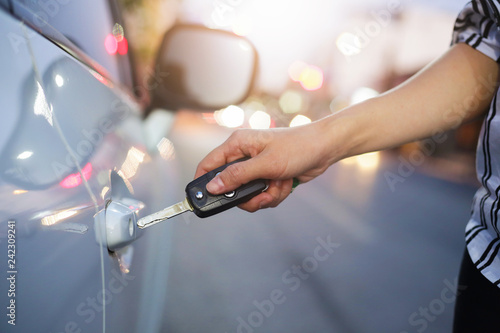 Hand of woman open with the key car.
