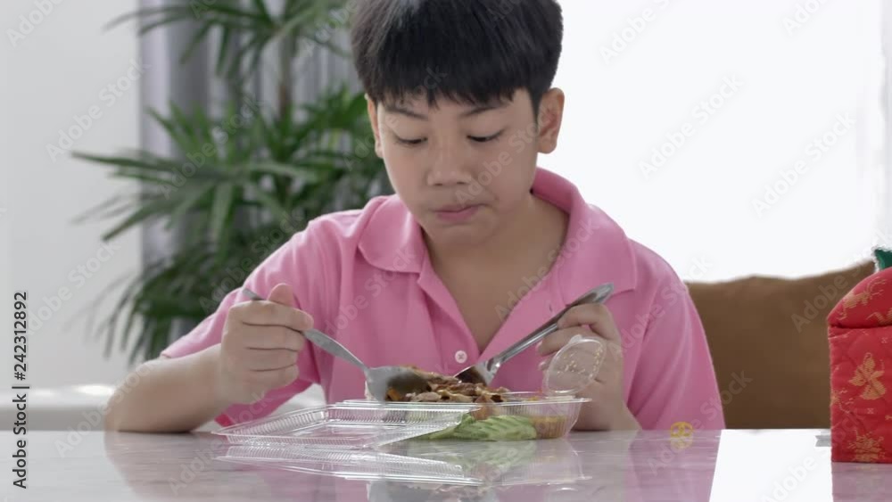 4K asian boy eating lunch at home , Food for lunch, lunchboxes with jasmine rice box. 4K asian boy eating lunch at home , Food for lunch, lunchboxes with jasmine rice box.